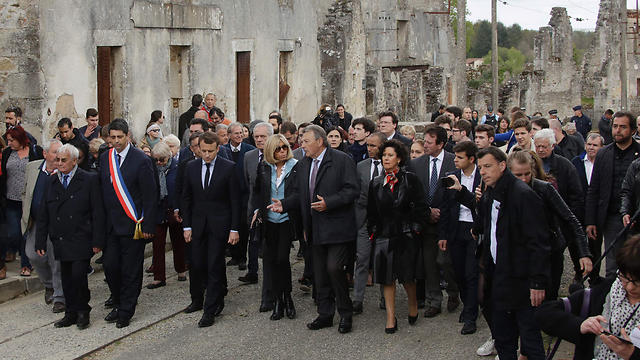 Emmanuel Macron (3rd L), flanked by his wife Brigitte Trogneux (4th L) and Robert Hébras (L), one of the survivors of the Oradour-sur-Glane massacre, visits the ruins. (Photo: AFP)