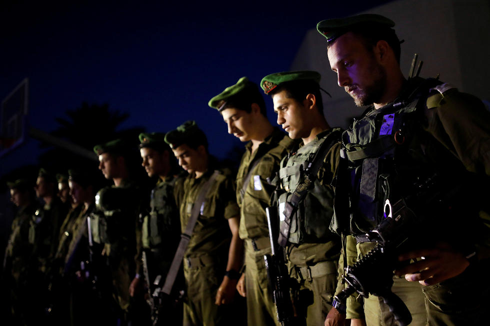 Israeli soldiers from the Nahal Brigade stand still in Netiv Haasara, just outside the northern Gaza Strip (Photo: Reuters)