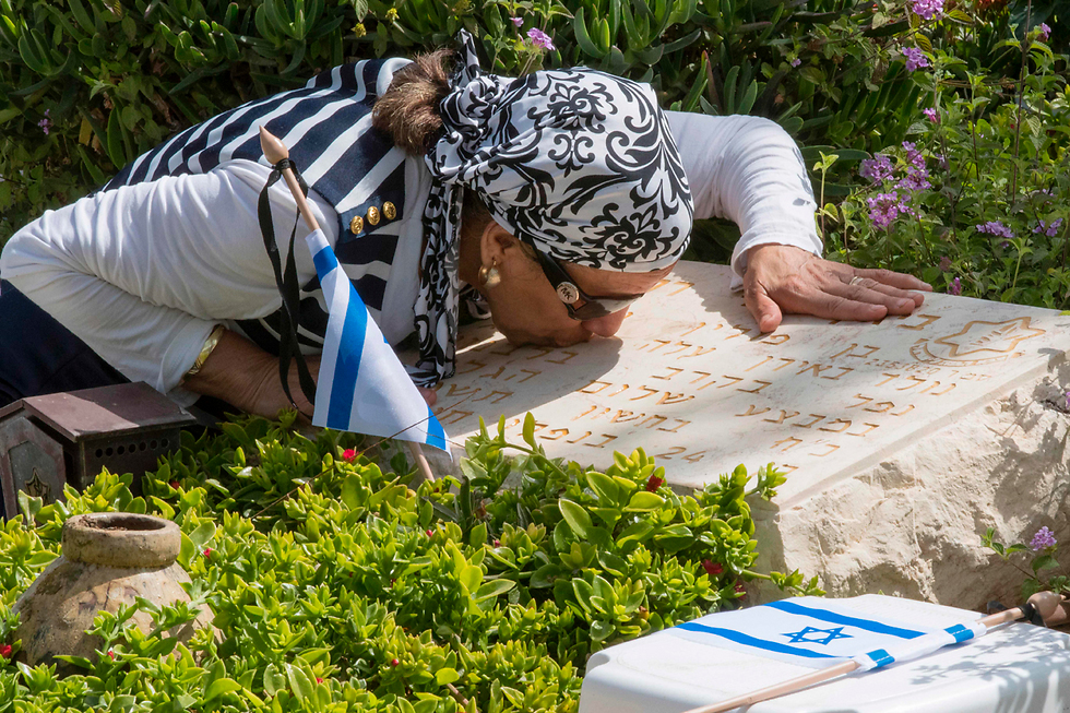 על קברו של סמל ראשון ביג'ן-דני רחמנו, שנפל ב-4 בנובמבר 1983 במלחמת לבנון הראשונה. הוא הותיר אחריו אישה הרה. את בתו שנולדה אחרי נופלו ונקראה דניאלה על-שמו, לא זכה לראות. כמו כן הותיר הורים, שלוש אחיות ואח  (צילום: AFP ) (צילום: AFP )