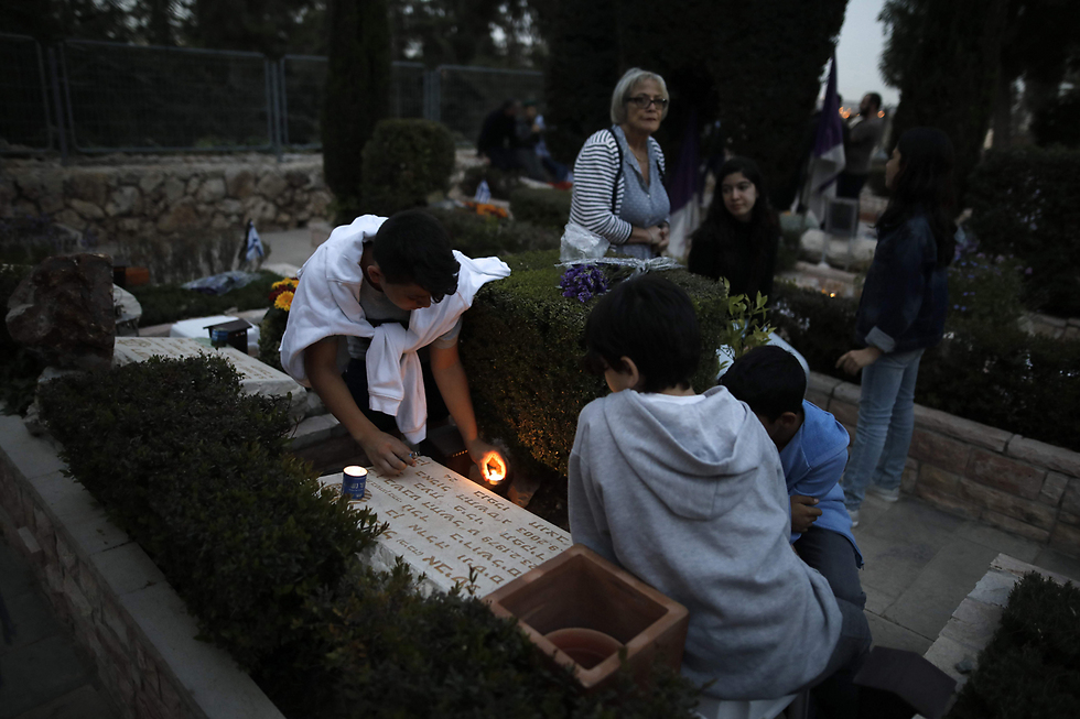 על קברו של מיכאל אביטל, מאבטח שב"כ, שנהרג בתאונת דרכים ב-2003. אביטל, בן 24 במותו, הותיר אחריו הורים ושתי אחיות (צילום: AFP) (צילום: AFP)