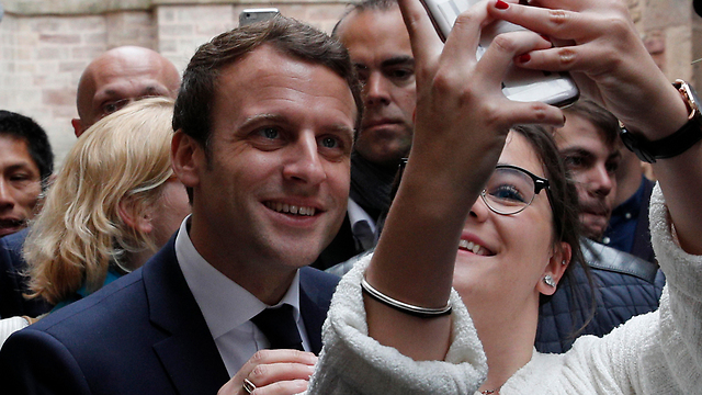 Macron posing with a fan (Photo: AP)