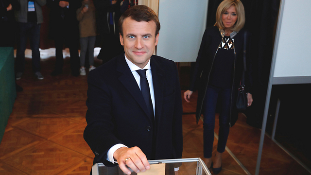 Macron votes earlier Sunday with his wife, Brigitte (Photo: AP)