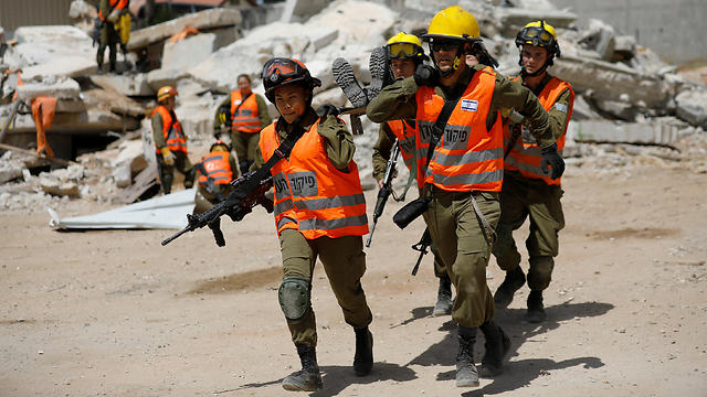 Joana Chris Arpon (front, L) helps evacuate her comrade during a drill at Tzrifin military base in central Israel. (Photo: Reuters)