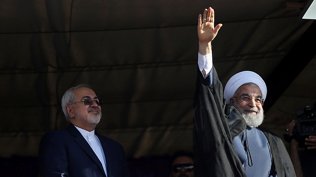 מוביל בסקרים. נשיא איראן חסן רוחאני לצד שר החוץ שלו מוחמד ג'וואד זריף בעצרת בחירות בעיר אספהאן (צילום: AP) (צילום: AP)