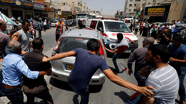 Palestinian rioters in Huwara attacking the settler's car (Photo: Reuters)