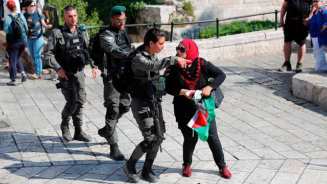 A pro-Palestinian protestor escorted by police (Photo: AFP)