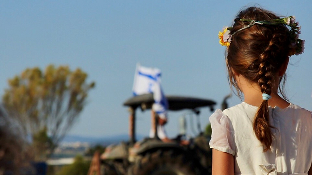 A girl in white looks on as all of Yokne'am celebrates Shavuot (Photo: Maya Shekel)