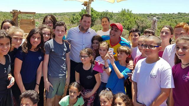 Yuval HaMebulbal (in the center wearing a red hat) with Samaria Regional Council head Dagan and children on the set of the movie (Photo: Roee Hadi)
