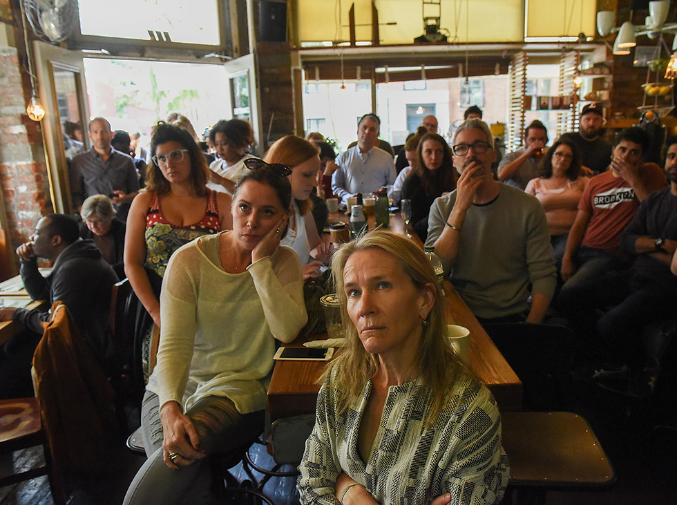 צופים בעדות במסעדה בניו יורק (צילום: AFP) (צילום: AFP)