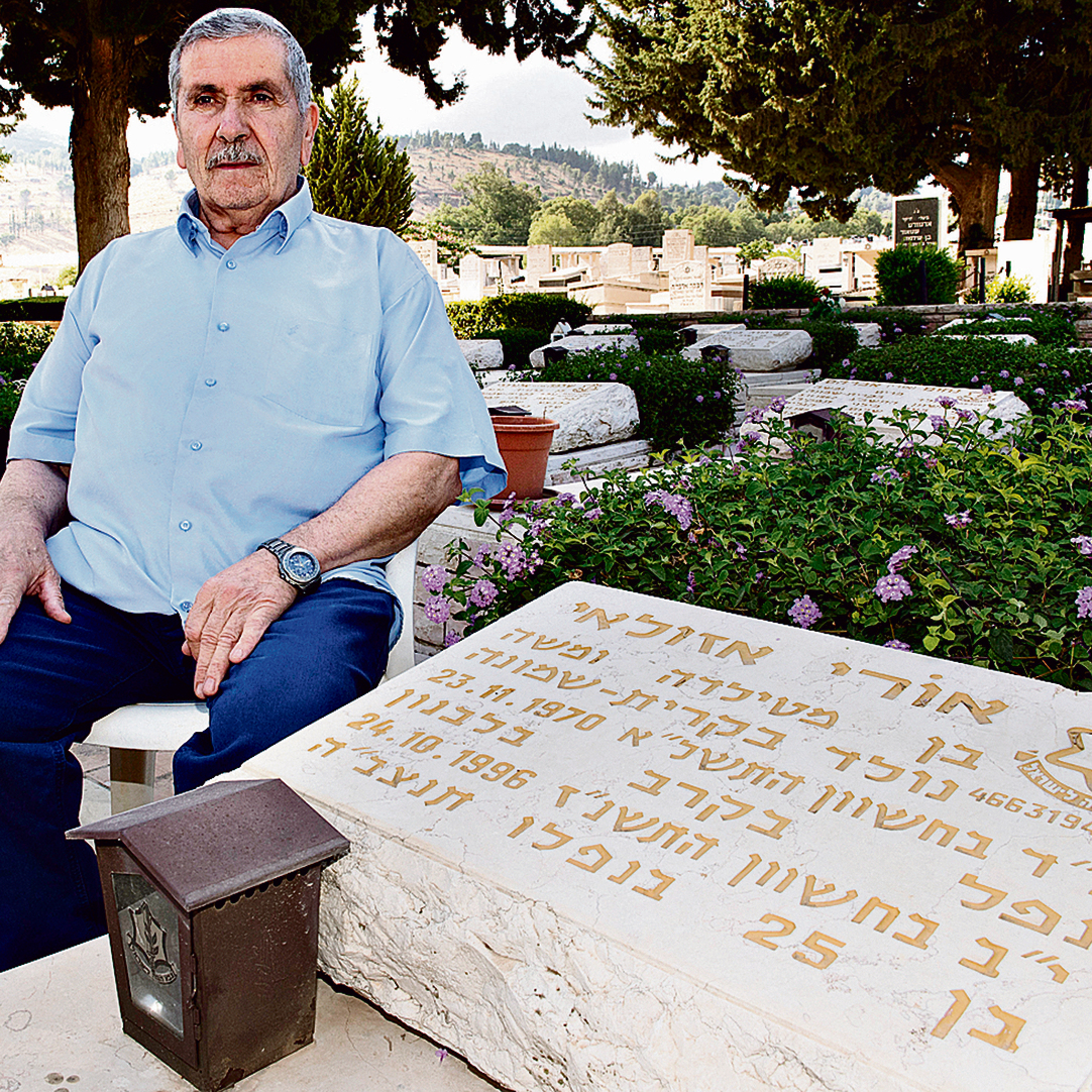 Moshe Azulai, sitting next to his son's tombstone (Photo: Effi Sharir)