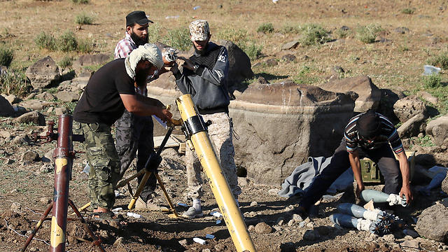 Syrian rebel fighters prepare to fire mortar shells towards forces loyal to Assad, Saturday (Photo: Reuters)