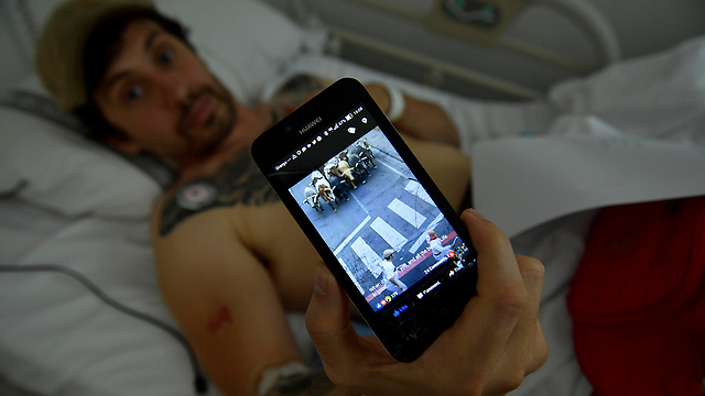 אחד הפצועים צופה בסרטון (צילום: AP) (צילום: AP)
