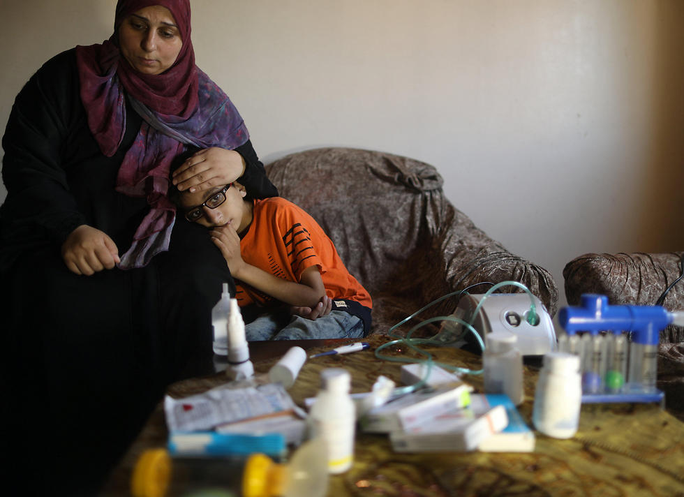 Mohammad Shanty, who suffers from cystic fibrosis, sits next to his mother after receiving oxygen therapy during a power cut in their family house, which is equipped with a backup battery-powered system (Photo: Reuters)