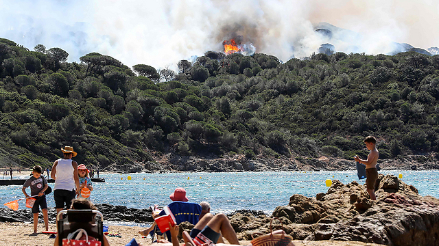 נופשים מביטים באש המשתוללת ליד סן טרופה (צילום: AFP) (צילום: AFP)