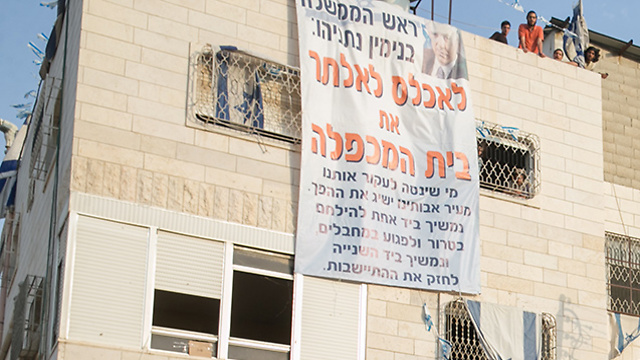 Settlers protesting atop the Machpela House (Photo: Ohad Zwigenberg)