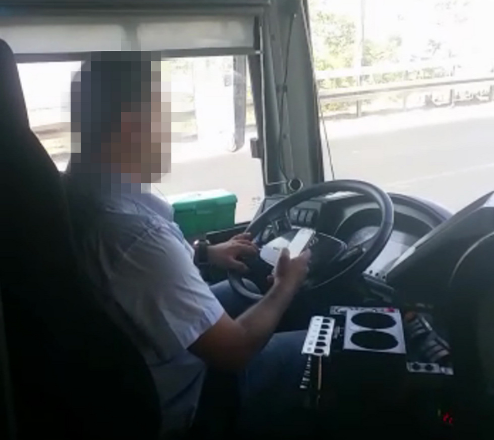 Водитель автобуса разговаривает по телефону во время вождения