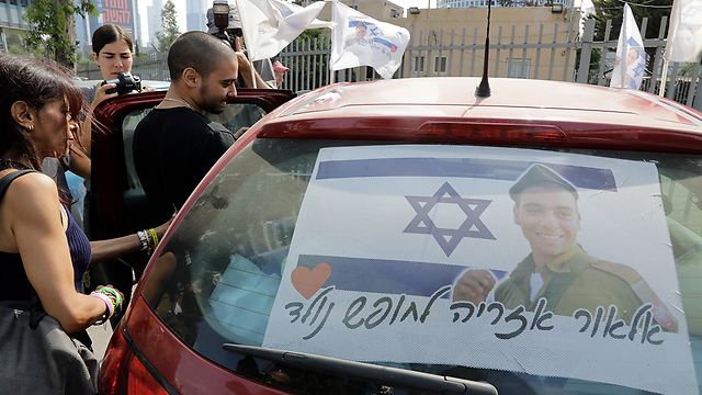 Azaria entering family car decorated with Israeli flags with his picture and the text: 'Elor Azaria born to be free' (Photo: Shaul Golan)
