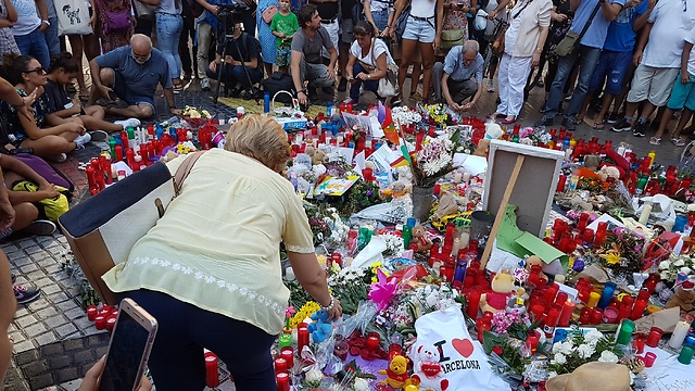 Mourners lay flowers at the makeshift memorial at Las Ramblas, Barcelona, the site of Thursday's attack (Photo: Yoav Zitun)