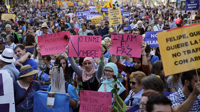 מוסלמיות עם שלטים: "איסלאם הוא שלום" ו"לא בשמי" (צילום: AP) (צילום: AP)