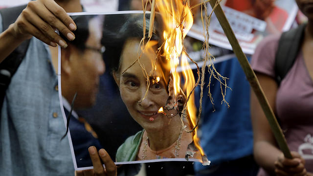 מפגינים בקולקטה, הודו, שורפים את תמונתה של סו צ'י (צילום: AP) (צילום: AP)