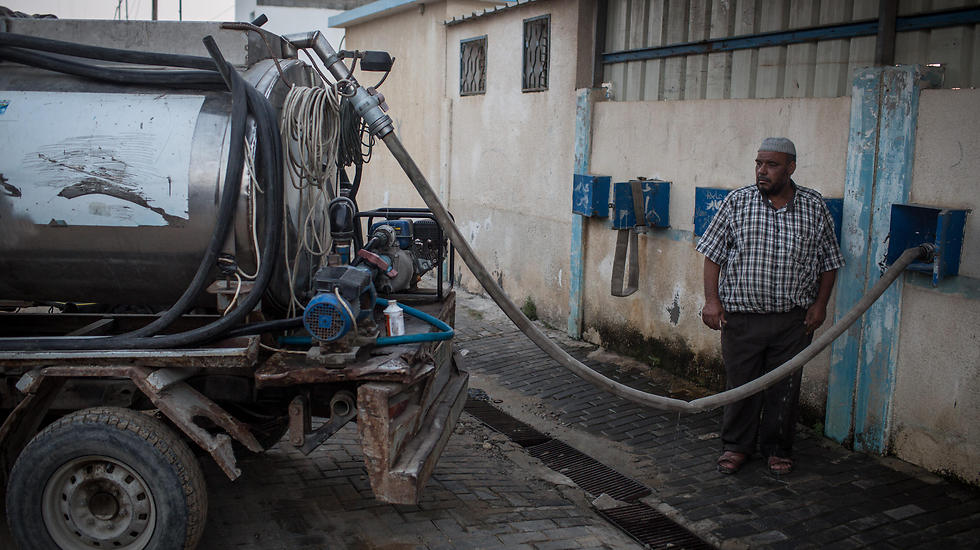 Palestinian man fills water truck from depot (Photo: Getty Images) (Getty Images)