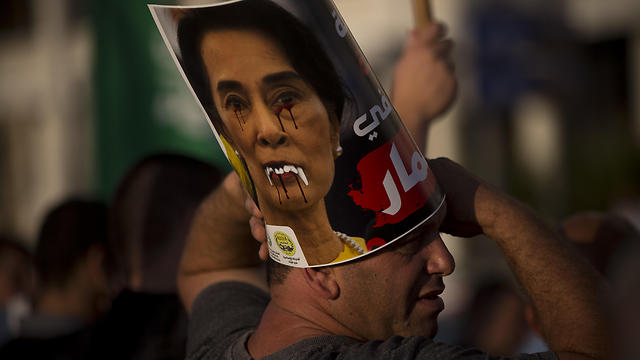 Displays a defaced poster of Myanmar's State Counsellor Aung San Suu Kyi (Photo: AP)