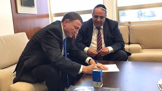 Guetta handing over his resignation letter to Speaker of the Knesset Yuli Edelstein
