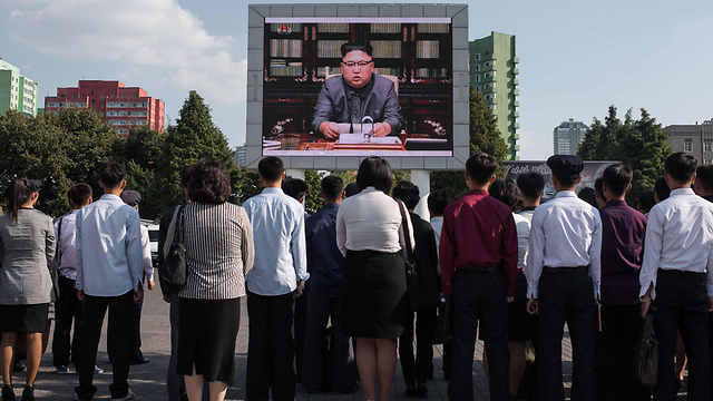 אזרחים צפון קוריאנים צופים בהכרזה של מנהיגם (צילום: AFP) (צילום: AFP)