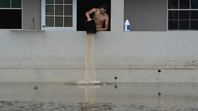תושב פוארטו ריקו מרוקן את ביתו ממים (צילום: AP) (צילום: AP)