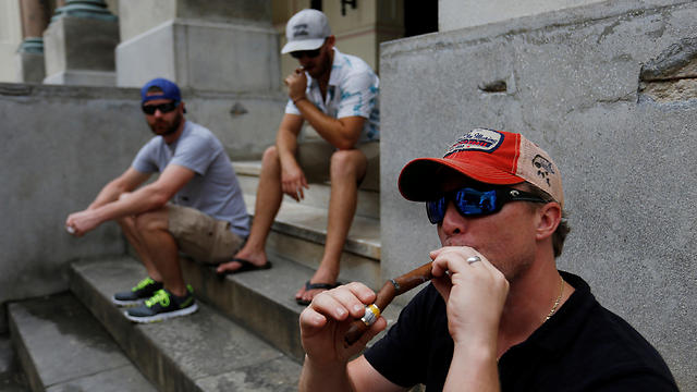 תיירים אמריקנים מעשנים סיגרים בבירת קובה (צילום: רויטרס) (צילום: רויטרס)