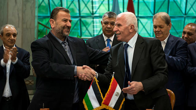 Hamas's Selah al-Arouri (L) and Fatah's al-Ahmad sign the historic agreement (Photo: EPA)