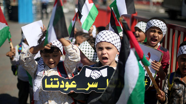 Children hold Palestinian flags as they celebrate the signing of the reconciliation deal