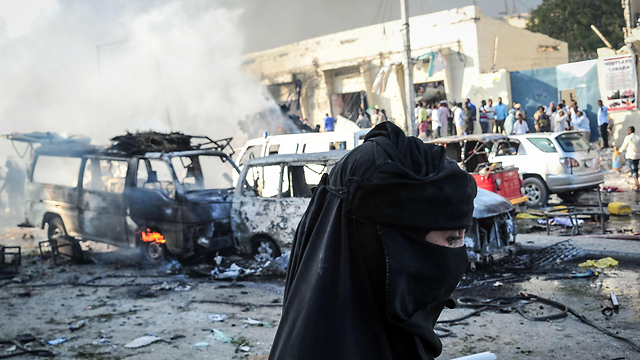A woman walks through the demolished site of the attack (Photo: AFP)