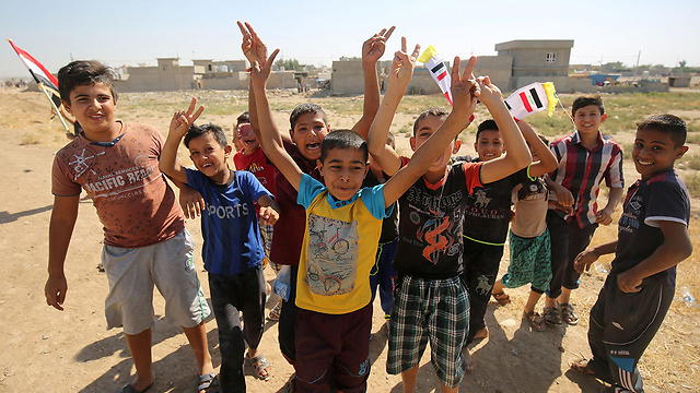 ילדים עיראקים מריעים לצבא שנכנס לכירכוכ (צילום: AFP) (צילום: AFP)