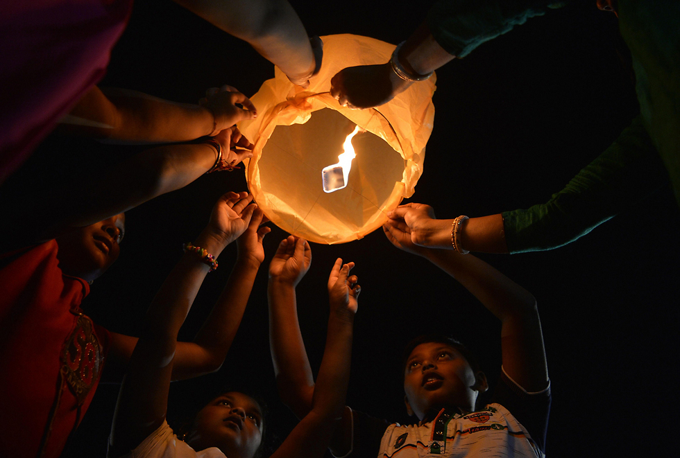 דיוואלי בהודו. ילדים משחררים פנסי נייר מתכלים כדי לעודד חגיגות יותר ידידותיות לסביבה (צילום: AFP) (צילום: AFP)