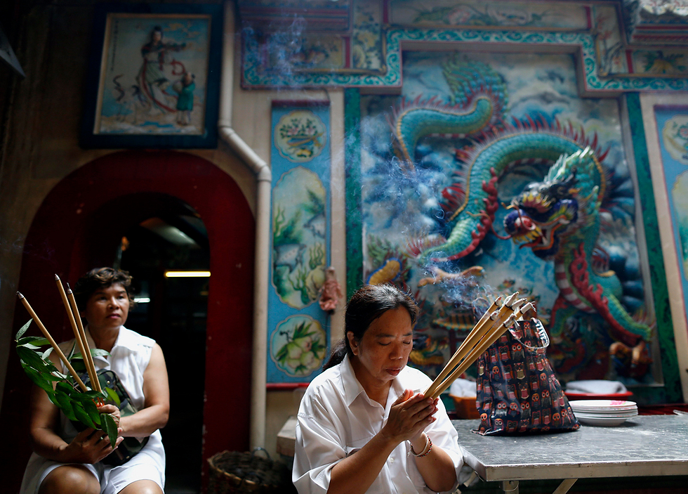 מתפללת בפסטיבל הצמחוני במקדש סיני בבנגקוק, תאילנד (צילום: EPA) (צילום: EPA)