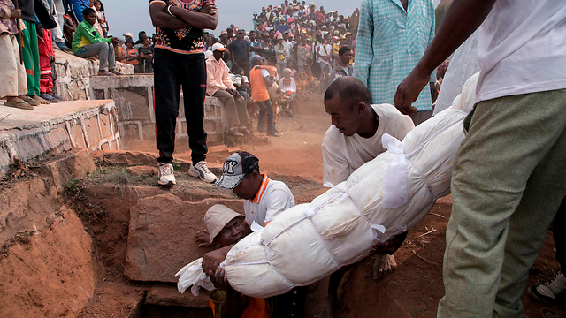 הוצאת גופה מאחד הקברים. "אבקש הצלחה במבחנים" (צילום: AFP) (צילום: AFP)