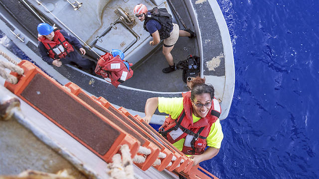טאשה מטפסת על הספינה האמריקנית אחרי החילוץ (צילום: AP) (צילום: AP)