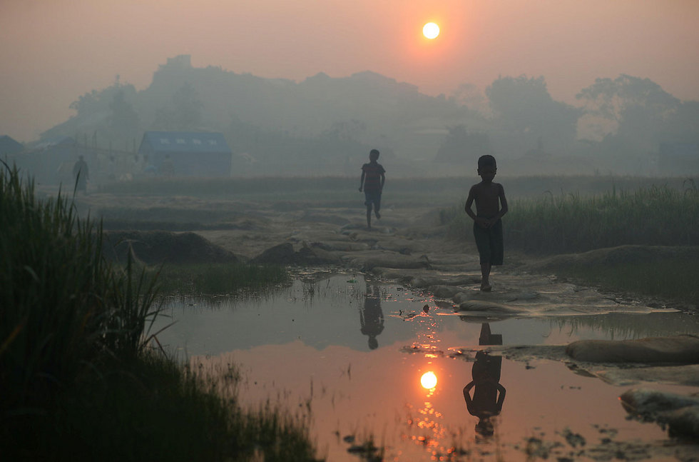 ילדים מבני הרוהינגיה במיאנמר, שנאלצו לברוח לבנגלדש השכנה על רקע גל אלימות קשה נגדם, צועדים בזריחה במחנה הפליטים שלהם (צילום: רויטרס) (צילום: רויטרס)