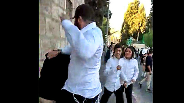 Haredi demonstrators attack a seuclar protester in Jerusalem (Photo: Yoni Krotenberg)