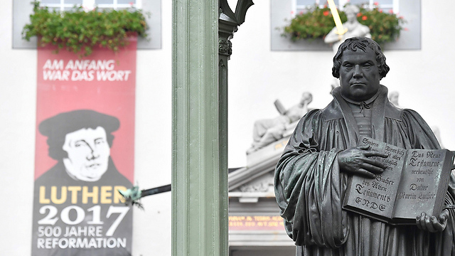 פסלו של מרתין לותר בעיר ויטנברג הגרמנית שבה תלה את חיבורו "95 התזות" (צילום: AFP) (צילום: AFP)