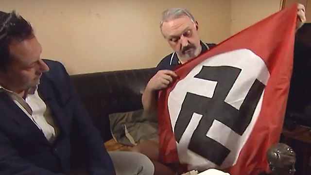 ווילשאו מציג את הדגל הנאצי שהיה תלוי בביתו, בראיון לערוץ 4 הבריטי ()