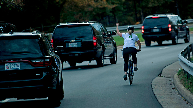 ג'ולי בריקסמן רוכבת אופניים אצבע משולשת לשיירה של דונלד טראמפ (צילום: AFP)