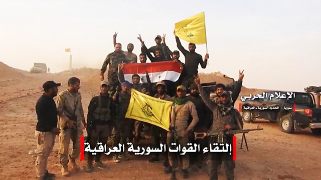 Members of Iranian-backed Shiite militias waving Hezbollah flags in Syria 