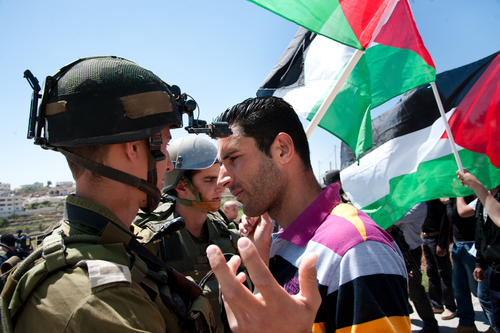 Израильский солдат и палестинские активисты. Фото: Ryan Rodrick Beiler shutterstock