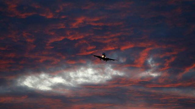 מטוס לקראת נחיתה בשעת שקיעה (צילום: EPA) (צילום: EPA)