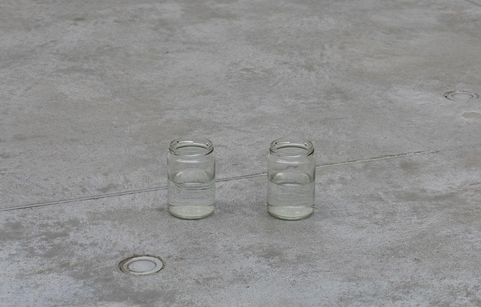 החלק השלישי במיצב: שתי צנצנות זכוכית, שמולאו למחצה במים. נאיטו לא הסכימה לגידורן, וכדי שהמבקרים לא ימעדו עליהן בטעות החליט המוזיאון להציב לידן שומר (צילום: אלעד שריג)
