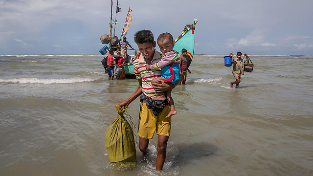 פליטים בני רוהינגה יורדים לחוף בבנגלדש (צילום: AP) (צילום: AP)
