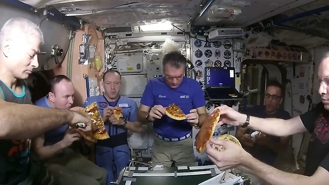 Космонавты едят пиццу на МКС. Фото: NASA