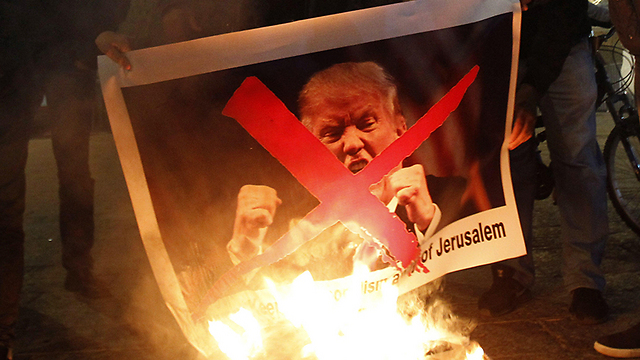 Protestors set fire to Trump’s picture in Bethlehem following declaration  (Photo: AFP)